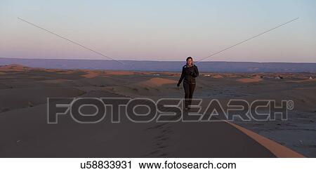 Woman walking on Erg Chegaga Dunes in Sahara Desert, Morocco View Large Photo Image Stock Image - Woman walking on Erg Chegaga Dunes in Sahara Desert, Morocco. Fotosearch