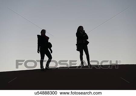 Women standing on Erg Chegaga Dunes in Sahara Desert, Souss-Massa-Draa, Morocco View Large Photo Image Stock Image - Women standing on Erg Chegaga Dunes in Sahara Desert, Souss-Massa-Draa, Morocco. Fotosearch