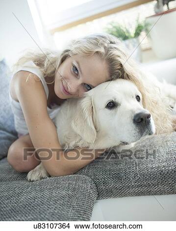 Beautiful woman hugging dog on sofa View Large Photo Image Picture - Beautiful woman hugging dog on sofa. Fotosearch