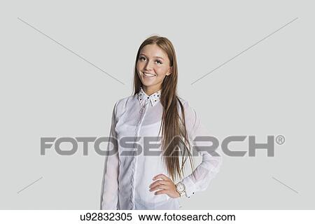 Stock Photography - Beautiful woman standing with hand on hip against white background. Fotosearch