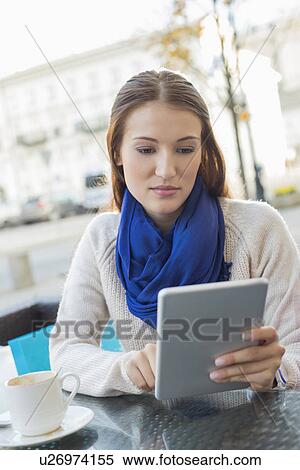 Beautiful woman using tablet PC at sidewalk cafe View Large Photo Image Stock Photography - Beautiful woman using tablet PC at sidewalk cafe. Fotosearch