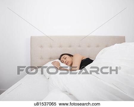 Stock Photography - Beautiful young woman sleeping in bed. Fotosearch