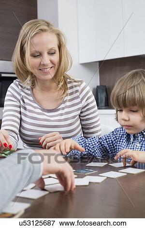 Boy playing cards with parents at home View Large Photo Image Stock Photo - Boy playing cards with parents at home. Fotosearch