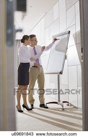 Stock Image - Business colleagues preparing for presentation in office. Fotosearch