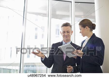 Business colleagues using digital tablet in office View Large Photo Image Picture - Business colleagues using digital tablet in office. Fotosearch