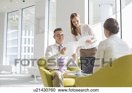 Stock Image - Business people working at office lobby. Fotosearch