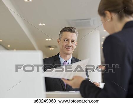 Stock Photo - Business people working in office cafeteria. Fotosearch