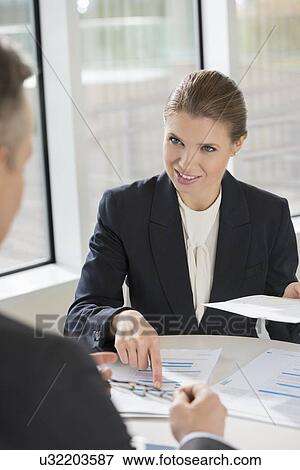 Businesswoman discussing with colleague at cafeteria View Large Photo Image Stock Photo - Businesswoman discussing with colleague at cafeteria. Fotosearch