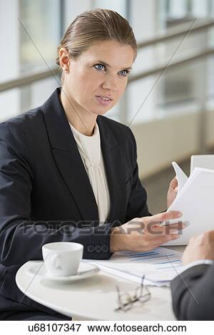 Businesswoman discussing with colleague during coffee break View Large Photo Image Stock Photo - Businesswoman discussing with colleague during coffee break. Fotosearch