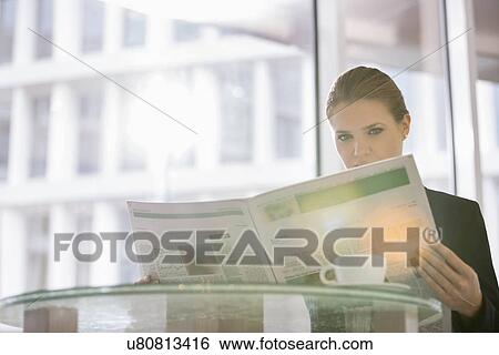 Businesswoman reading newspaper at office cafe View Large Photo Image Stock Photograph - Businesswoman reading newspaper at office cafe. Fotosearch