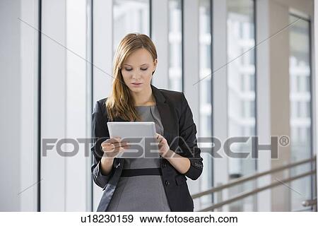 Businesswoman using tablet PC in office View Large Photo Image Stock Photo - Businesswoman using tablet PC in office. Fotosearch