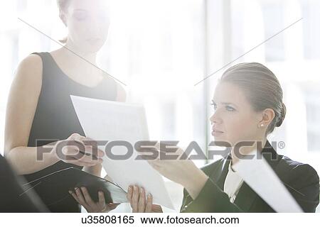 Businesswomen doing paperwork in office View Large Photo Image Stock Photography - Businesswomen doing paperwork in office. Fotosearch