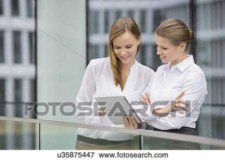 Businesswomen using digital tablet in office View Large Photo Image Stock Photo - Businesswomen using digital tablet in office. Fotosearch