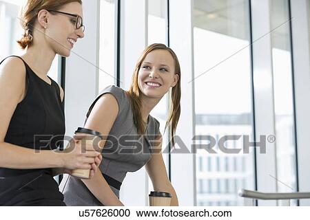 Businesswomen with disposable coffee cups at office View Large Photo Image Stock Image - Businesswomen with disposable coffee cups at office. Fotosearch
