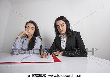 Businesswomen working at desk in office View Large Photo Image Stock Image - Businesswomen working at desk in office. Fotosearch
