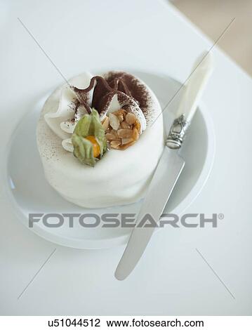 Stock Image - Close-up of cake and table knife on plate. Fotosearch