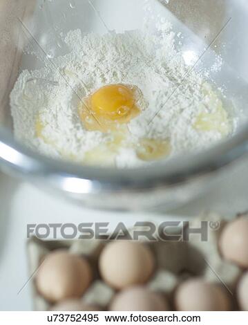 Stock Photography - Close-up of raw egg and flour. Fotosearch