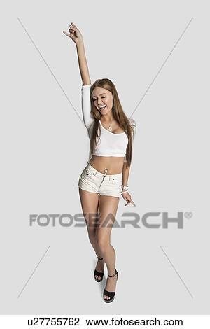 Excited woman dancing against gray background View Large Photo Image Stock Image - Excited woman dancing against gray background. Fotosearch