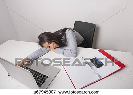 Exhausted businesswoman sleeping at office desk View Large Photo Image Stock Photo - Exhausted businesswoman sleeping at office desk. Fotosearch