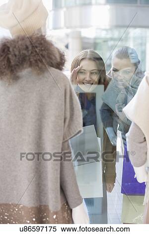 Female friends window shopping View Large Photo Image Stock Photography - Female friends window shopping. Fotosearch