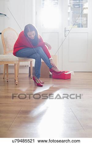 Full length of young woman trying on footwear in store View Large Photo Image Stock Image - Full length of young woman trying on footwear in store. Fotosearch