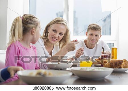 Happy family with children having breakfast at table View Large Photo Image Stock Photography - Happy family with children having breakfast at table. Fotosearch