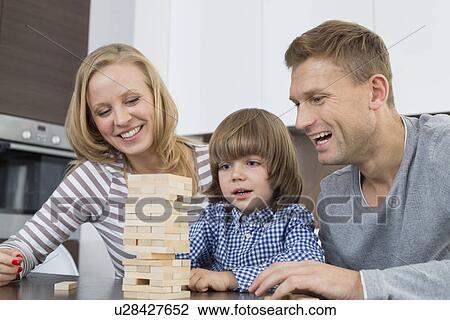 Happy parents and son playing with wooden blocks at home View Large Photo Image Stock Image - Happy parents and son playing with wooden blocks at home. Fotosearch