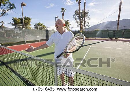 Happy senior male tennis player offering handshake on court View Large Photo Image Stock Photography - Happy senior male tennis player offering handshake on court. Fotosearch