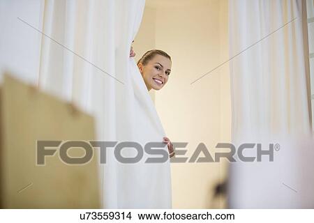Happy woman in hiding behind curtains in store View Large Photo Image Picture - Happy woman in hiding behind curtains in store. Fotosearch