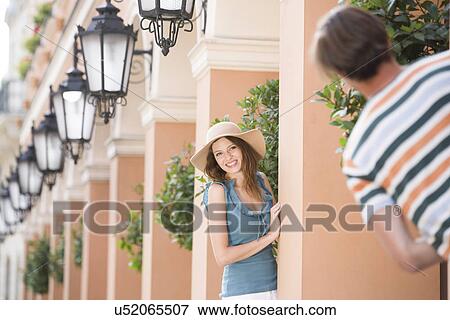 Happy woman playing hide-and-seek with man amongst pillars View Large Photo Image Stock Photo - Happy woman playing hide-and-seek with man amongst pillars. Fotosearch