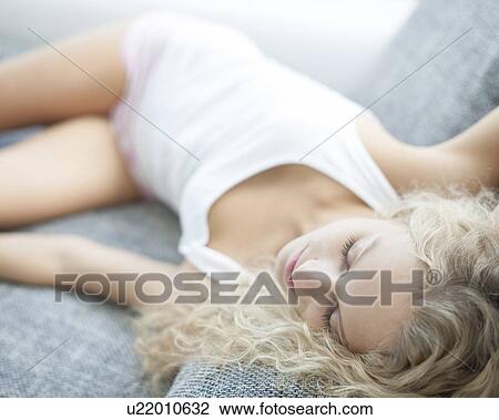 High angle view of woman sleeping on sofa at home View Large Photo Image Stock Image - High angle view of woman sleeping on sofa at home. Fotosearch