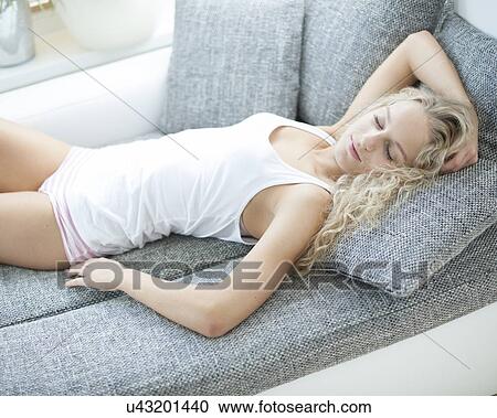 High angle view of woman sleeping on sofa at home View Large Photo Image Stock Image - High angle view of woman sleeping on sofa at home. Fotosearch