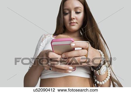Stock Image - Low angle view of woman text messaging. Fotosearch