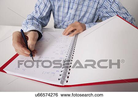 Midsection of senior businessman writing in file at desk View Large Photo Image Stock Photograph - Midsection of senior businessman writing in file at desk. Fotosearch