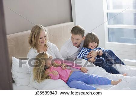Parents playing with children in bedroom View Large Photo Image Stock Photo - Parents playing with children in bedroom. Fotosearch