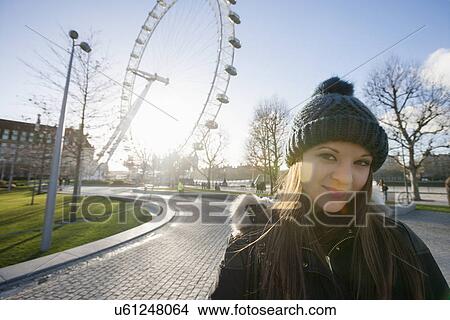 Portrait of beautiful young woman in front of London Eye, London, UK View Large Photo Image Picture - Portrait of beautiful young woman in front of London Eye, London, UK. Fotosearch