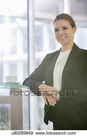 Stock Photo - Portrait of confident businesswoman standing in office. Fotosearch