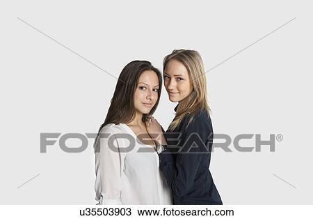 Portrait of confident female friends against white background View Large Photo Image Stock Image - Portrait of confident female friends against white background. Fotosearch