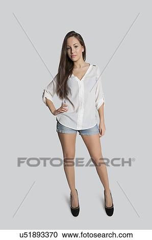 Portrait Of Confident Teenage Girl In Hot Pants Posing Over Gray Background Portrait Of Confident Teenage Girl In Hot Pants Posing Over Gray Background