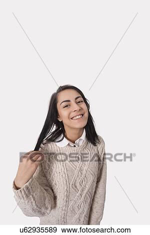 Stock Photo - Portrait of happy businesswoman against gray background. Fotosearch