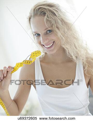 Portrait of happy woman holding fork wrapped with measuring tape View Large Photo Image Stock Photography - Portrait of happy woman holding fork wrapped with measuring tape. Fotosearch