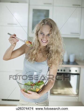 Portrait of happy woman mixing salad in kitchen View Large Photo Image Picture - Portrait of happy woman mixing salad in kitchen. Fotosearch