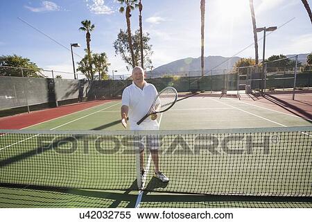 Portrait of senior tennis player offering handshake on court View Large Photo Image Stock Photography - Portrait of senior tennis player offering handshake on court. Fotosearch