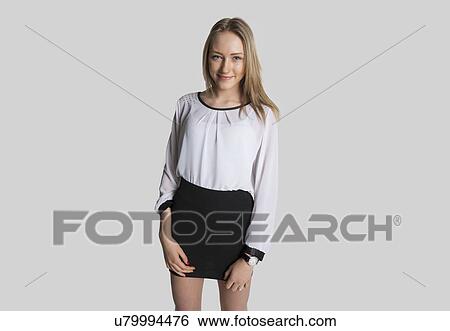 Portrait of smiling girl wearing mini dress over gray background View Large Photo Image Stock Photograph - Portrait of smiling girl wearing mini dress over gray background. Fotosearch