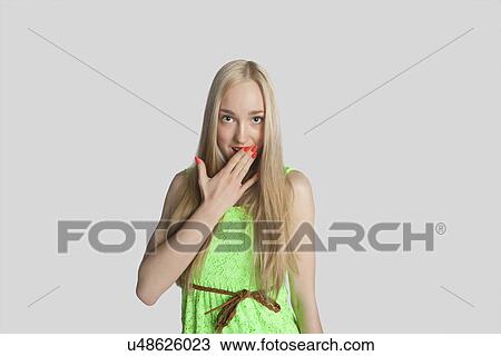 Portrait of surprised teenage girl with hand over mouth over gray background View Large Photo Image Stock Image - Portrait of surprised teenage girl with hand over mouth over gray background. Fotosearch