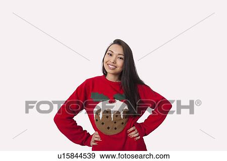 Portrait of woman in Christmas sweater standing with hands on hips over gray background View Large Photo Image Stock Photo - Portrait of woman in Christmas sweater standing with hands on hips over gray background. Fotosearch
