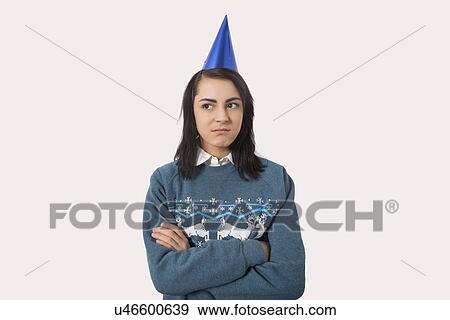 Portrait of woman wearing Christmas jumper and party hat against gray background View Large Photo Image Stock Photo - Portrait of woman wearing Christmas jumper and party hat against gray background. Fotosearch