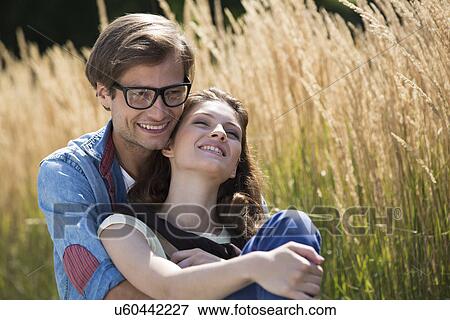 Romantic couple relaxing in field View Large Photo Image Stock Photo - Romantic couple relaxing in field. Fotosearch