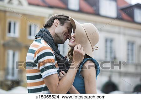 Romantic young man kissing woman against buildings View Large Photo Image Picture - Romantic young man kissing woman against buildings. Fotosearch