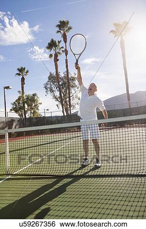 Stock Photograph - Senior male tennis player playing on court. Fotosearch